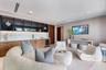 Built-in bar featuring wood cabinetry, stone-surface countertop, under-cabinet lighting, glass-front upper storage, and an integrated beverage refrige