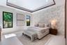 Tray ceiling with dark wood-finish trim, patterned wallpaper accent wall, large picture windows with black frames, and neutral tile flooring