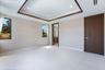 Tray ceiling with dark wood-finish trim, recessed lighting, large-format tile flooring, and solid core doors