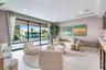 Floor-to-ceiling sliding glass walls, recessed ceiling lighting, light-toned oversized tile flooring, built-in cabinetry, and integrated ceiling speak