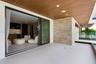 Covered balcony featuring wood-plank ceiling, large-format tile flooring, stacked-stone accent wall, recessed lighting, and expansive glass sliding do