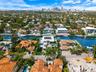 Aerial perspective of waterfront property featuring deep-water canal access, private boat dockage, and a multi-level structure with roof terrace and f