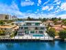 Modern waterfront residence featuring clean-lined architecture with multi-level design, expansive glass walls and sliding doors, open-air balconies wi