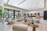 Open-concept living area featuring large-format tile flooring, a recessed tray ceiling with integrated lighting, expansive floor-to-ceiling glass slid