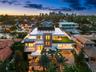 Multi-level contemporary residence featuring a rooftop terrace, tiered balconies with glass railings, composite stone exterior detailing, integrated r