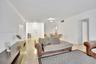 Open-concept interior featuring smooth-finish tile flooring, recessed crown molding, and neutral wall tones
