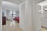 Polished stone flooring, floor-to-ceiling windows, and white bifold closet doors