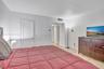 Neutral interior space featuring polished stone flooring, a single-panel interior door with louvered detail, and smooth-finish walls