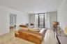 Living space featuring polished stone flooring, crown molding, and floor-to-ceiling glass sliding doors