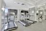 Fitness center featuring large windows, recessed ceiling lighting, wall-mounted sconces, and crown molding