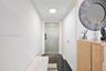 Entryway featuring polished dark stone flooring, high-gloss finish entry door with electronic keypad, and floor-to-ceiling built-in closet with dual d