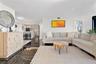 Open-concept interior featuring large-format polished dark stone flooring, recessed lighting, and kitchen cabinetry with integrated stainless steel ap