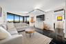 Living area featuring floor-to-ceiling windows, black polished stone-finish flooring, and adjustable track lighting