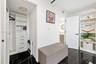 Custom walk-in closet featuring white built-in shelving, integrated dresser drawers with matte black hardware, floor-to-ceiling cabinetry, and polishe