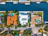 Waterfront property featuring a private dock, swimming pool, and paved driveway
