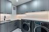 Modern cabinetry with matte hardware, light-toned countertop, undermount sink with a matte black faucet, and under-cabinet integrated lighting