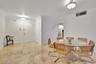 Neutral stone tile flooring, crown molding, and two semi-flush mount ceiling light fixtures