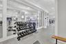 Fitness facility featuring wall-to-wall mirrors, recessed lighting, drop ceiling panels, and durable composite flooring