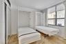 Built-in dual wall-mounted beds, stone-finish flooring, and sliding-door closets with mirrored panels
