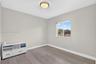 Neutral-toned interior featuring wood-finish flooring, a flush-mount ceiling light fixture, and a single-hung window