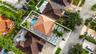 Aerial view featuring a tile roof, an in-ground swimming pool with an attached spa, and geometric concrete pavers