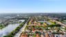 Aerial perspective of a residential property featuring a tiled roof, multi-car garage, and an in-ground swimming pool