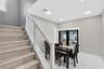 Staircase featuring wood-finish treads, custom white horizontal metal railing, recessed ceiling lighting, and large-format tile flooring