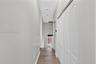 Hallway featuring wood-finish flooring, white paneled closet doors, and recessed ceiling lighting