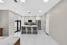 Kitchen featuring floor-to-ceiling cabinetry, a central island with a stone-surface countertop, stainless steel appliances, and large-format tile floo