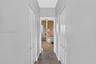 Hallway featuring wood-finish flooring and two sets of arched-panel bi-fold doors
