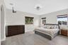 Spacious room featuring wood-finish flooring, multi-pane windows with horizontal blinds, an arched entryway, and a geometric flush-mount light fixture