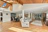 Vaulted wood-plank ceiling, skylights, recessed lighting, structural support columns, and wood-finish flooring