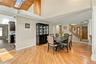 Vaulted ceilings with wood-plank detailing, recessed lighting, skylight, wood-finish flooring, and a staircase with decorative wood railings