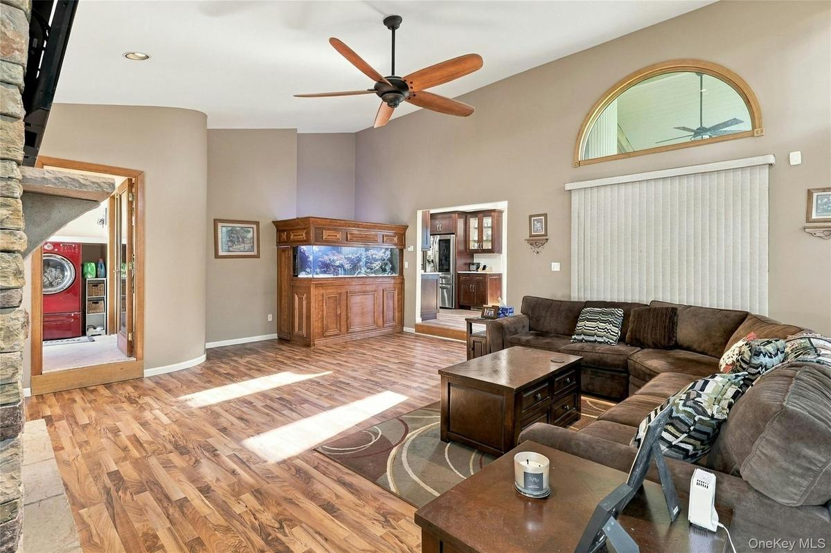 Vaulted ceilings, wood-finish flooring, arched transom window, built-in cabinetry, and recessed lighting