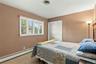Room featuring neutral wall tones, wall-to-wall carpeting, a multi-pane window with adjustable blinds, and a built-in double-door closet