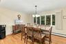 Wood-finish flooring, oversized multi-pane window, and four-light metal chandelier