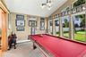 Vaulted ceiling featuring a multi-bulb pendant light, expansive floor-to-ceiling windows, and wall-to-wall carpeting