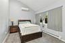 Vaulted ceilings featuring a wall-mounted ductless heating and cooling unit, neutral carpeting, and a window with hardware
