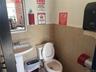 Bathroom featuring toilet and tile walls