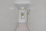Interior hall featuring white tile flooring, neutral wall finishes, and a flush-mount light fixture