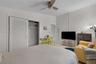 Room featuring neutral-toned walls, tile flooring, a ceiling fan with integrated lighting, and a closet with louvered doors