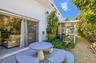Exterior patio featuring a concrete dining table with curved benches, sliding glass doors, and a screened-in lanai