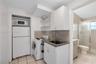 Kitchen featuring white cabinetry, solid-surface countertop, hexagonal tile backsplash, and ceramic tile flooring