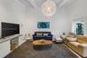 High vaulted ceilings featuring exposed structural beams, a statement spherical pendant light fixture, and floor-to-ceiling glass sliding doors