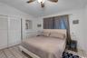 Ceramic tile flooring, built-in recessed cabinetry, and ceiling fan with integrated lighting