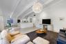 Vaulted ceilings with exposed structural beams, tile flooring, large spherical pendant light fixture, and built-in cabinetry