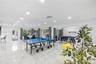 Open-concept interior featuring large-format tile flooring, recessed ceiling lighting, and multiple sliding glass doors providing access to the exteri