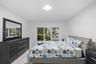 Neutral-toned interior space featuring white walls, bright flush-mount ceiling lighting, large horizontal window, and wood-finish flooring