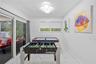 Large-format stone-finish tile flooring, recessed geometric ceiling lighting, and expansive glass sliding doors