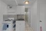 Kitchenette featuring white cabinetry, a neutral-toned countertop, a hexagonal tile backsplash, a white four-burner gas range, and a drop-in sink
